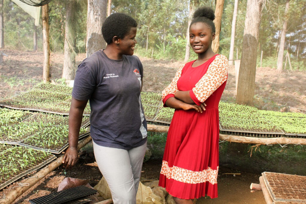 Linda, left, shows the progress of her agribusiness with the help of irrigation, alongside her daughter.